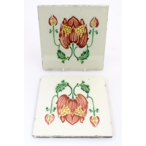 85 - Two tiles decorated with stylised tulip / flower detail. Marked Made in England verso. Approx. 6