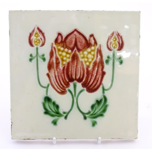 85 - Two tiles decorated with stylised tulip / flower detail. Marked Made in England verso. Approx. 6