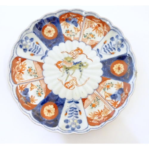 9 - An Oriental plate in the Imari palette decorated with big cat / leopard / cheetah to centre and a bo... 