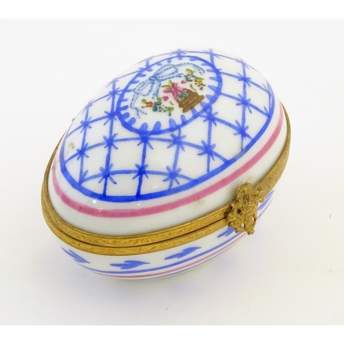 92 - A Limoges hand painted trinket box of egg form with bell and floral detail. Marked under. Approx. 1 ... 