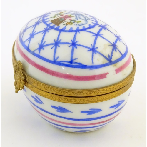 92 - A Limoges hand painted trinket box of egg form with bell and floral detail. Marked under. Approx. 1 ... 