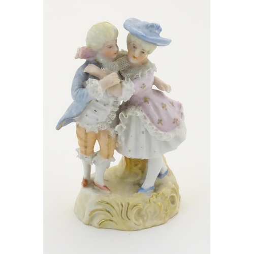 95 - A Continental figural group depicting a man and woman in 18thC dress with porcelain lace detail and ... 