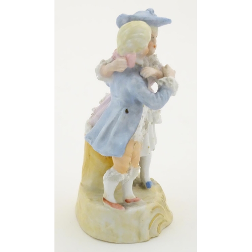 95 - A Continental figural group depicting a man and woman in 18thC dress with porcelain lace detail and ... 