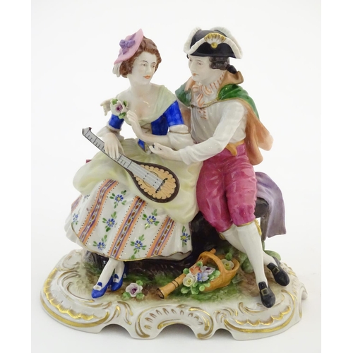 97 - Two German porcelain figures, a model of a young man holding a hat and flower with a dog beside him,... 