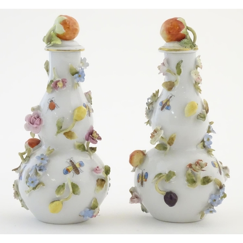 99 - A pair of Continental lidded vases decorated with insects and relief flowers, the lids topped with s... 