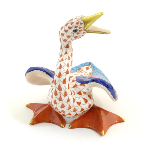 126 - A Herend pottery model of a honking goose with fishnet decoration and gilt highlights. Marked under.... 