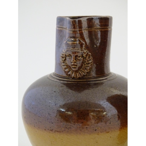 138 - A Doulton Lambeth two tone stoneware jug with relief mask detail to neck. Marked under. Together wit... 