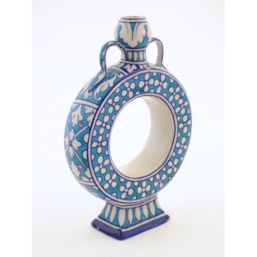 120 - A moon flask / doughnut vase with Persian style palette and decorated with floral detail. Approx. 9