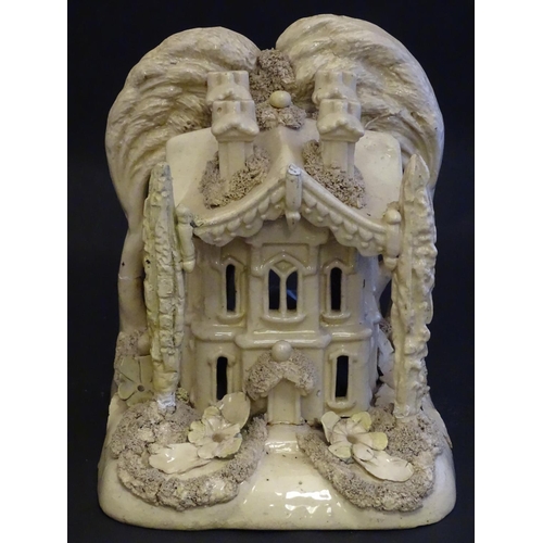 81 - A large Victorian Staffordshire creamware pastille burner modelled as a house and garden with trees.... 