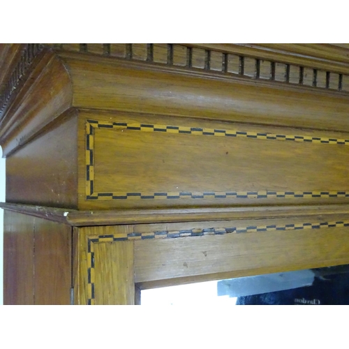 1469 - An early / mid 20thC oak triple wardrobe, having a moulded dentil carved cornice above a checkered i... 