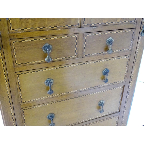 1469 - An early / mid 20thC oak triple wardrobe, having a moulded dentil carved cornice above a checkered i... 