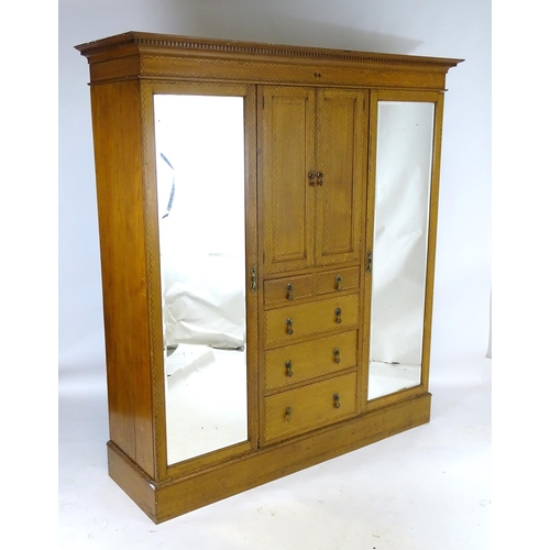 1469 - An early / mid 20thC oak triple wardrobe, having a moulded dentil carved cornice above a checkered i... 