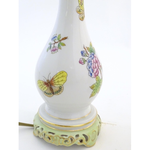 132 - A pair of Herend pottery table lamps decorated with flowers, foliage and butterflies. Marked under. ... 