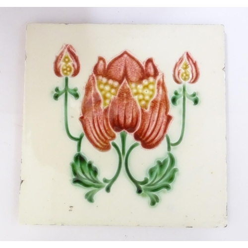 85 - Two tiles decorated with stylised tulip / flower detail. Marked Made in England verso. Approx. 6