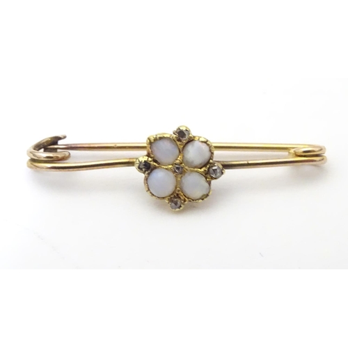 923 - A yellow metal bar brooch set with opals and diamonds. Approx. 1 1/4