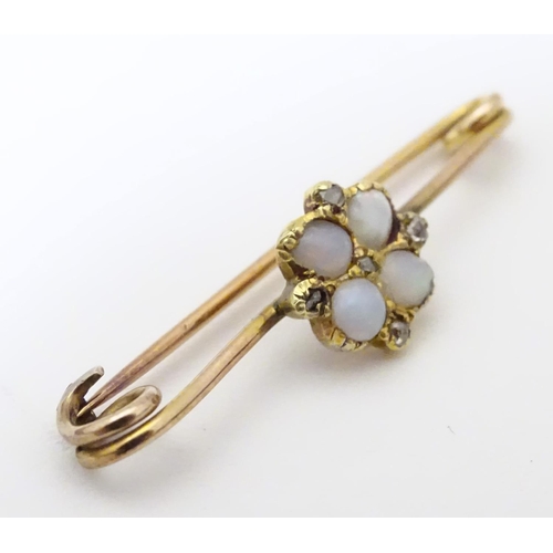 923 - A yellow metal bar brooch set with opals and diamonds. Approx. 1 1/4