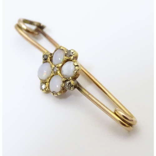 923 - A yellow metal bar brooch set with opals and diamonds. Approx. 1 1/4