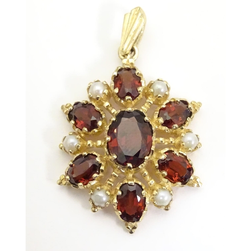 928 - A 9ct gold pendant set with garnets and seed pearls. Approx. 1 1/2