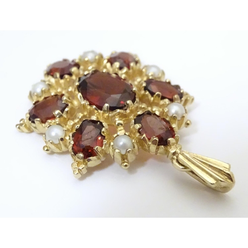 928 - A 9ct gold pendant set with garnets and seed pearls. Approx. 1 1/2