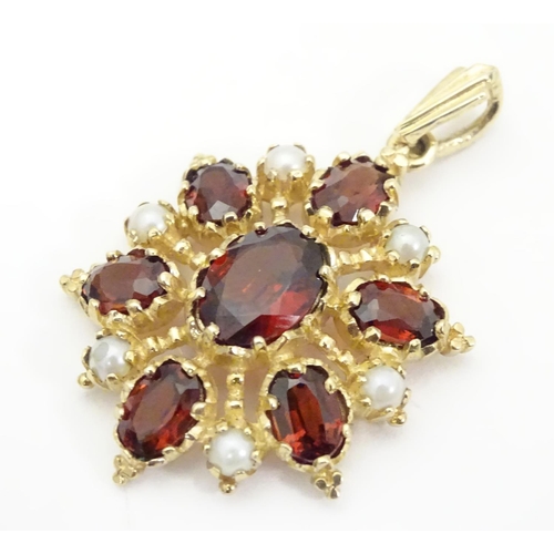 928 - A 9ct gold pendant set with garnets and seed pearls. Approx. 1 1/2