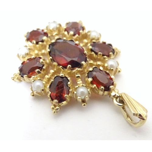 928 - A 9ct gold pendant set with garnets and seed pearls. Approx. 1 1/2