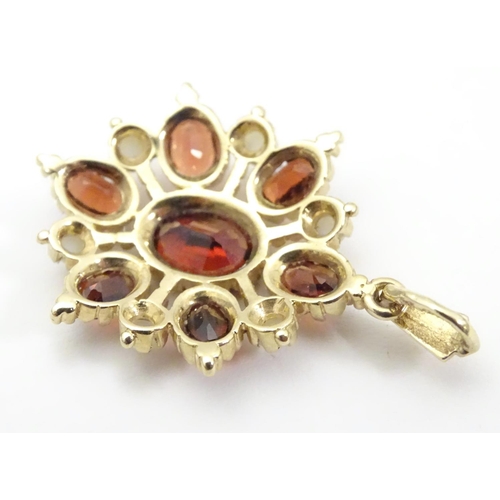 928 - A 9ct gold pendant set with garnets and seed pearls. Approx. 1 1/2