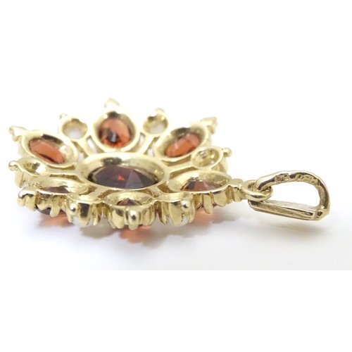 928 - A 9ct gold pendant set with garnets and seed pearls. Approx. 1 1/2