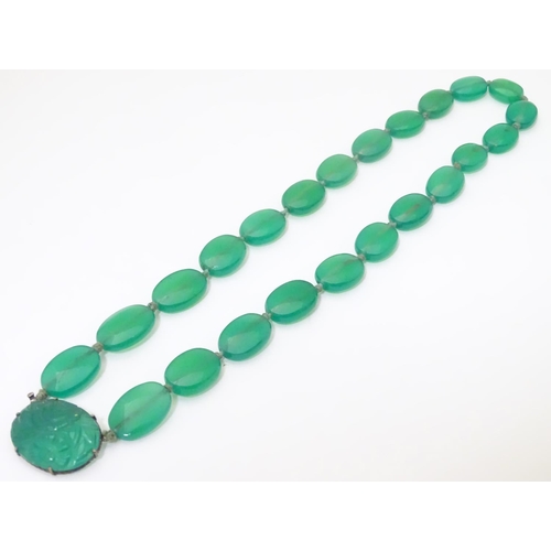 933 - A vintage bead necklace comprising 23 green jade coloured ovoid beads with engraved clasp and .935 s... 