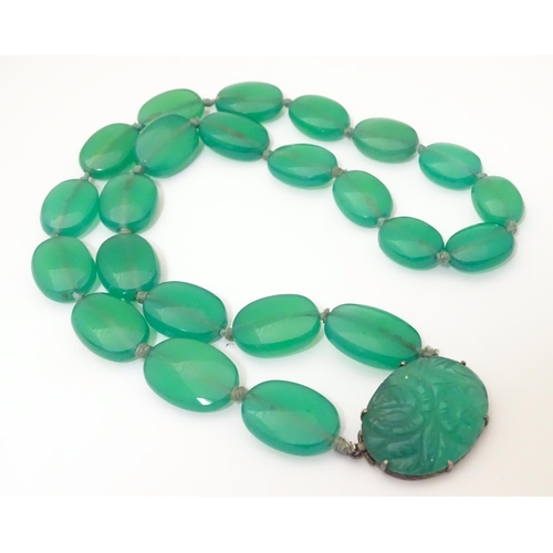 933 - A vintage bead necklace comprising 23 green jade coloured ovoid beads with engraved clasp and .935 s... 