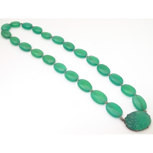 933 - A vintage bead necklace comprising 23 green jade coloured ovoid beads with engraved clasp and .935 s... 