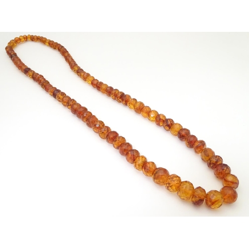 945 - A graduated bead necklace of facet cut amber coloured beads Approx 32