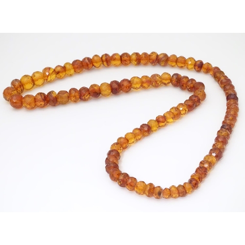 945 - A graduated bead necklace of facet cut amber coloured beads Approx 32