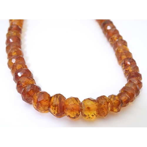 945 - A graduated bead necklace of facet cut amber coloured beads Approx 32