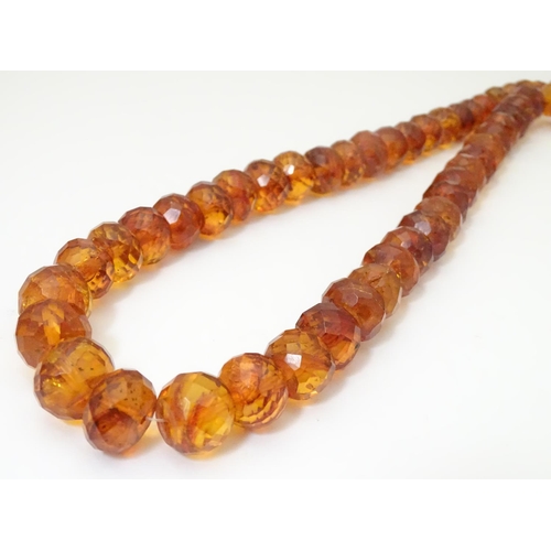 945 - A graduated bead necklace of facet cut amber coloured beads Approx 32