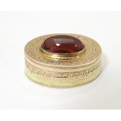 956 - A Victorian yellow metal vinaigrette with engraved decoration set with garnet cabochon to top, openi... 