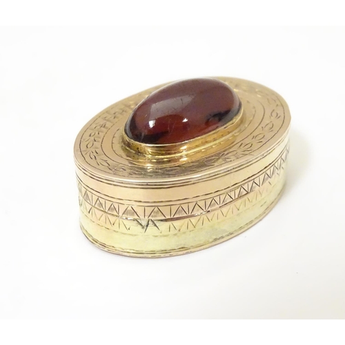 956 - A Victorian yellow metal vinaigrette with engraved decoration set with garnet cabochon to top, openi... 