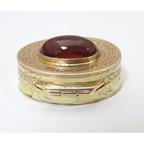 956 - A Victorian yellow metal vinaigrette with engraved decoration set with garnet cabochon to top, openi... 