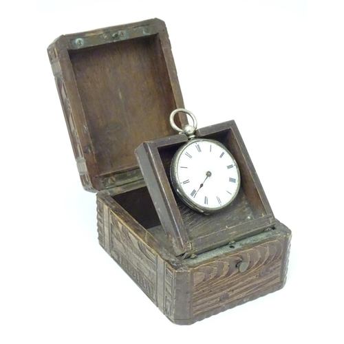 968 - A carved pocket watch travelling case / stand. Together with a pocket / fob watch. (2)