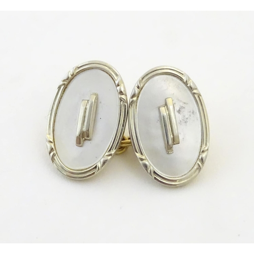 943 - A pair of Art Deco cufflinks with mother of pearl style detail marked 18CT and with makers monogram ... 