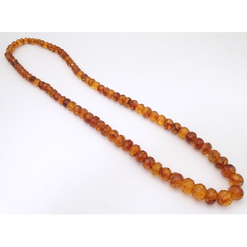 945 - A graduated bead necklace of facet cut amber coloured beads Approx 32