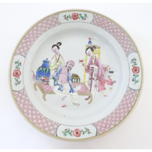 3 - A Chinese famille rose plate decorated with an interior scene with an elderly scholar on a day bed w... 