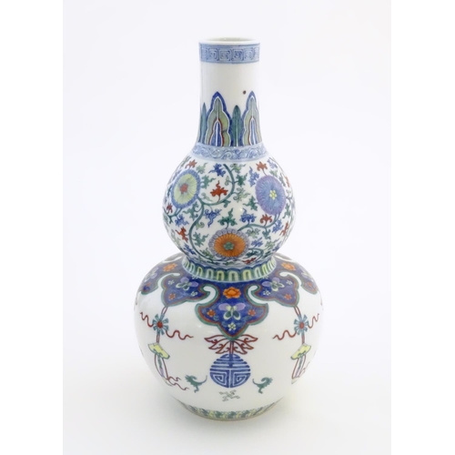 12 - A Chinese double gourd vase with doucai style decoration with scrolling floral and foliate detail. C... 
