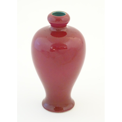 16 - A Chinese baluster vase with a bulbous rim, with a ruby pink glaze and a turquoise interior. Charact... 