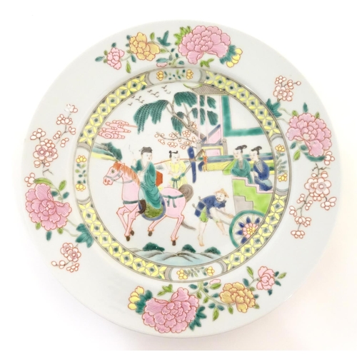 20 - A Chinese famille rose plate depicting a landscape scene with a figure on horse back with an attenda... 