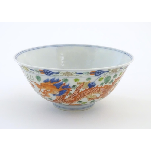 24 - A Chinese bowl with dragon and flaming pearl detail, with flowers, foliate and stylised clouds. Char... 