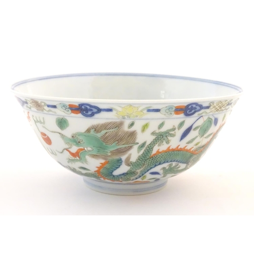 24 - A Chinese bowl with dragon and flaming pearl detail, with flowers, foliate and stylised clouds. Char... 