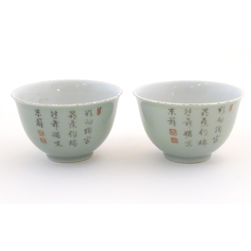 39 - A pair of Chinese tea bowls decorated with flowers and Oriental script. Character marks under. Appro... 