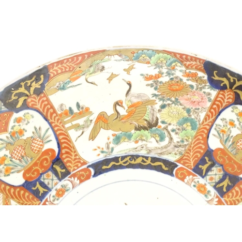 56 - A Japanese Kutani charger with central animal with stylised flames, the border decorated with panels... 