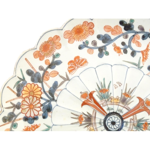 57 - An Oriental plate with a scalloped rim decorated in the Imari palette with floral and foliate detail... 