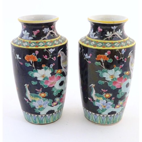 58 - A pair of Oriental vases decorated with stylised pheasants amongst flowers. Character marks under. L... 